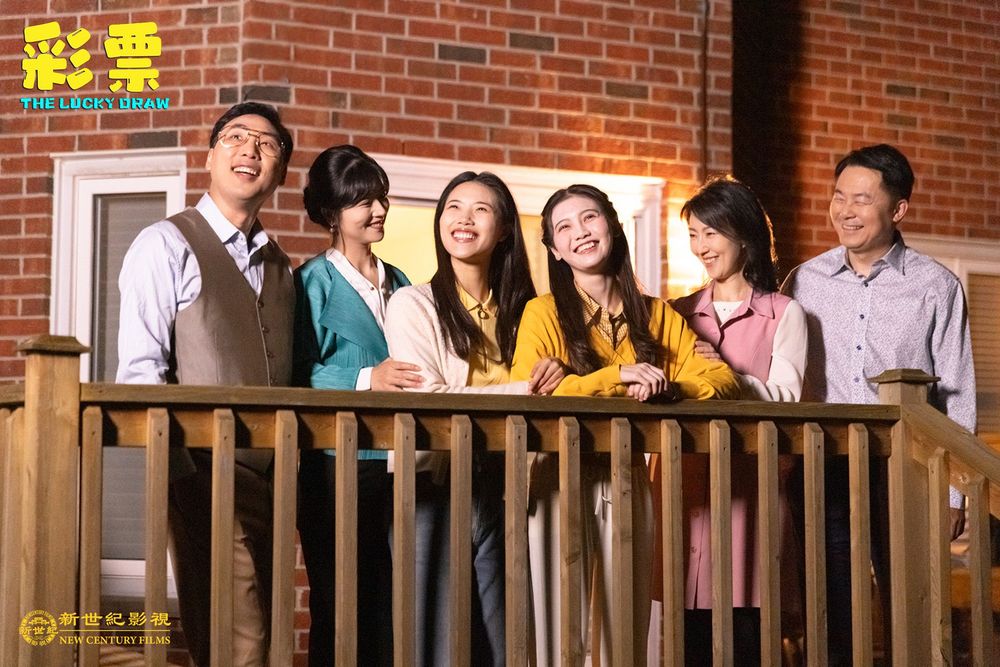Still from The Lucky Draw: a family on a balcony, smiling and looking up